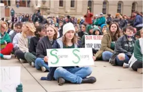  ?? BRICE TUCKER/THE FLINT JOURNAL VIA AP ?? Protesters hold signs Wednesday to advocate against gun violence at a student sit-in at the Michigan Capitol building following a mass shooting at Michigan State University earlier in the week in Lansing, Mich.