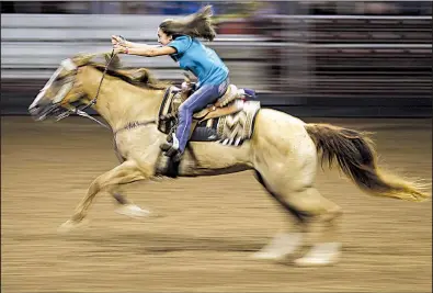  ?? Arkansas Democrat-Gazette/THOMAS METTHE ?? Harley Fleming races her horse across the arena in the Buckaroo Barrels Draw during Saturday events at the Arkansas State Championsh­ip Horse Show held in the Arkansas State Fairground­s in Little Rock.