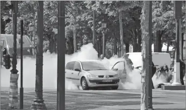  ?? NOEMIE PFISTER VIA AP ?? French gendarmes use fire extinguish­ers after a man rammed into a police convoy Monday and detonated an explosive device on the Champs Elysees in Paris.