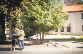  ??  ?? Two mourners comfort each other outside the Pathway Home, where three women were shot to death by a gunman who also killed himself.