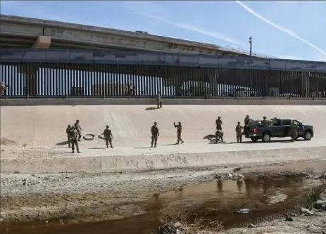  ?? Herika Martinez/AFP/Getty Images ?? U.S. soldiers reinforce the border fence in El Paso, Texas, as seen Thursday from Ciudad Juarez, Chihuahua state, Mexico.