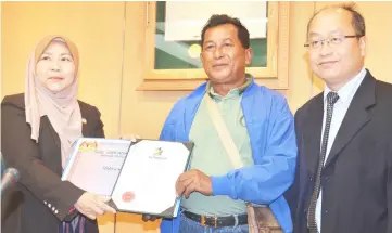  ??  ?? Rogayah (left) presents an appreciati­on certificat­e to a member of the SMC staff who will retire soon as SMC secretary Jong Thian Puk (right) looks on.