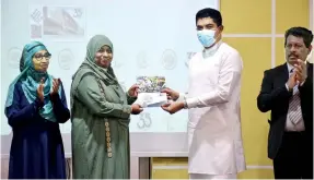  ?? ?? Mr Shantha Bandara, Honourable Acting Minister of Mass Media, ceremonial­ly presenting the cover to the Principal of ILMA Internatio­nal Girls’ School, Mrs Sarah Hussain.