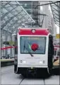  ?? Christina Ryan/calgary Herald ?? Mayor Naheed Nenshi drives a CTrain through a ribbon for the west LRT launch ceremony Saturday.