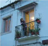  ?? ARMANDO FRANCA/AP ?? Georgina Simoes stands on the balcony of her rented apartment March 10 in Lisbon. The nursing home caregiver, 57, earns less than $845 a month.