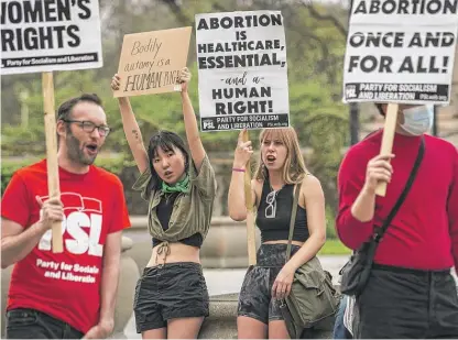  ?? ASHLEE REZIN/SUN-TIMES ?? Angelina Han, 20, and Emma Macfadyen, 20, both from Chicago, join other abortion rights activists on Michigan Avenue in the Loop on Wednesday.