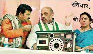  ??  ?? BJP President Amit Shah with BJP Delhi Chief Manoj Tiwari and MP Meenakshi Lekhi listens to Prime Minister Narendra Modi’s ‘Mann Ki Baat’ radio programme at Guru Ravi Das Dham slum at R K Puram in New Delhi on Sunday