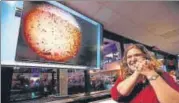  ?? AP ?? ▪ A NASA engineer smiles next to an image of Mars sent from InSight shortly after it landed on the red planet.