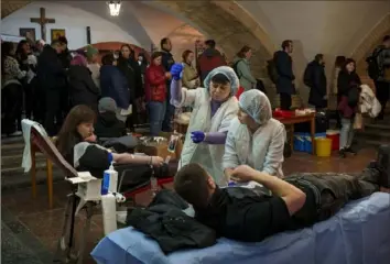  ?? Vadim Ghirda/Associated Press ?? People wait in line to donate blood for wounded Ukrainian personnel Tuesday during an event in the basement of St. Nicholas Roman Catholic Church, in Kyiv, Ukraine.