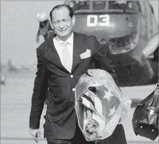  ?? THE ASSOCIATED PRESS ?? US ambassador John Gunther Dean clutches the American flag that had flown over the US Embassy in Phnom Penh as he is evacuated in April 1975.