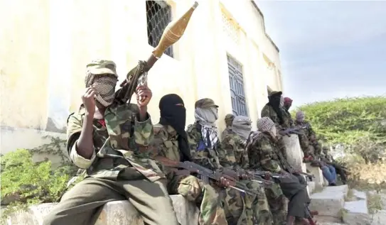  ??  ?? Al-Shabab militants sit outside a building in Dayniile, Somalia, in a file photo. (Reuters)