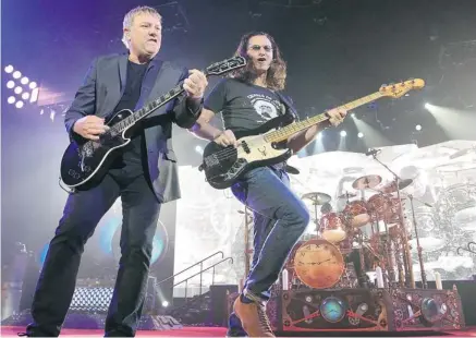  ?? Stuart Gradon/calgary Herald ?? Rush members, from left, Alex Lifeson, Geddy Lee and Neil Peart perform in Red Deer on Wednesday for a flood benefit concert.