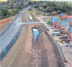  ?? DRONE PHOTO: COLIN ABLITT ?? A drone’s-eye view of the St John’s Reach section of the Lichfield Canal, showing one of the bridges between the new Southern Bypass and St John’s Grange housing developmen­t and beyond that the pinch point between the bypass and existing cottage gardens.