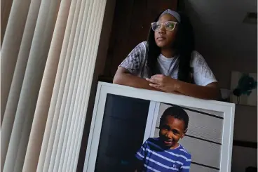  ?? Associated Press ?? ■ Charron Powell stands with a photo of her son, LeGend Talieferro, on Oct. 3 at her home in Raytown, Mo. LeGend was 4 years old when he was fatally shot June 29, 2020, while sleeping at his father’s apartment.
