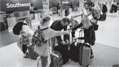  ?? Jon Shapley / Staff photograph­er ?? Stacy Pitts, from right, daughter Avery, 10, husband Kevin, daughter Ellie, 13, and daughter Addy, 14, prepare for a flight at Hobby on the Monday before Thanksgivi­ng last year. Flights at Hobby will be slightly lower this year, higher at Bush Interconti­nental.