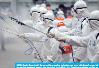  ??  ?? DAEGU, South Korea: South Korean soldiers wearing protective gear spray disinfecta­nt as part of preventive measures against the spread of the COVID-19 at Dongdaegu railway station on Saturday. —AFP