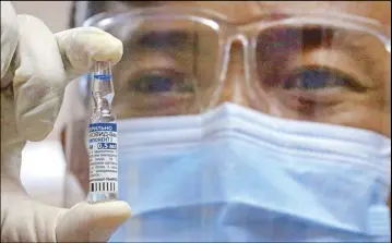  ?? EDD GUMBAN ?? A doctor at the Sta. Ana hospital in Manila holds up an ampoule of Russia’s Sputnik V vaccine during an inoculatio­n of medical frontliner­s yesterday.