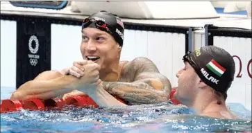  ?? Gary Ambrose For The Times ?? U.S. SWIMMER Caeleb Dressel, left, greets second-place finisher Kristof Milak of Hungary after Dressel’s world-record time in the 100-meter butterfly in Tokyo. Dressel broke his own mark set in 2019.