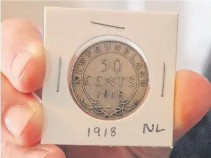  ?? CAMERON KILFOY • SALTWIRE ?? Bradley Reid of St. John's has been collecting coins for nearly a decade. He said he has 12 Newfoundla­nd coins in his collection. In his hand is a 50-cent sliver coin from 1918.