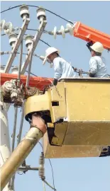  ??  ?? LINESMEN install new power lines in Manila.