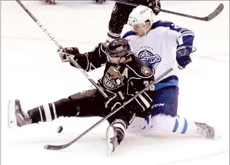  ?? — Photo by Keith Gosse/The Telegram ?? St. John’s IceCaps’ centre Blair Riley (right) takes down the Hershey Bears’ Garrett Mitchell during their AHL game at Mile One Centre Saturday night. The IceCaps lost 4-0 the night after having beaten the Bears 5-1 at Mile One.