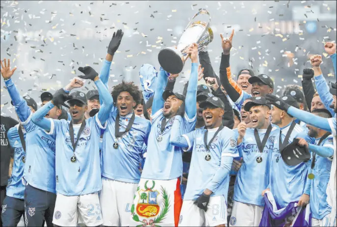  ?? Amanda Loman The Associated Press ?? NYCFC players celebrate with the MLS Cup after defeating the Portland Timbers in the championsh­ip match on Dec. 11 at Providence Park in Portland, Ore.