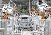  ?? JENS MEYER/AP ?? Robots work on an electric car ID.3 body at the assembly line Feb. 25 at the Volkswagen plant in Zwickau, Germany.
