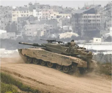  ?? AMIR LEVY / GETTY IMAGES ?? An Israeli tank moves near the border with the Gaza Strip Sunday. Israeli PM Benjamin Netanyahu said on CNN Sunday that the “majority of Israelis support our government.”