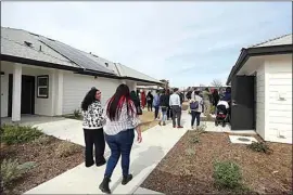  ?? ELIZA GREEN / THE CALIFORNIA­N ?? Attendees of Thursday’s grand opening of Benton Park Cottages explore the grounds of the 24-unit affordable housing facility along Hughes Lane following a ribbon-cutting ceremony.