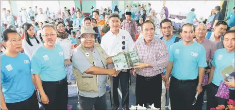  ??  ?? Len (front row, third right) receiving newly published booklet on ‘Birds of Kuala Baram Wetland’ from Musa Musbah, chairman of MNS Miri Chapter.