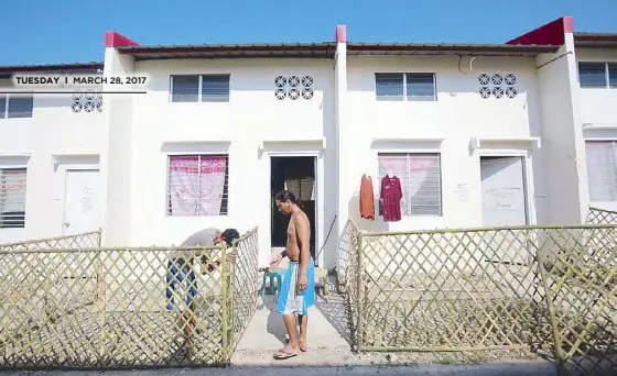  ?? MICHAEL VARCAS ?? Occupants of a government housing project in Pandi, Bulacan put up fences around their units yesterday.