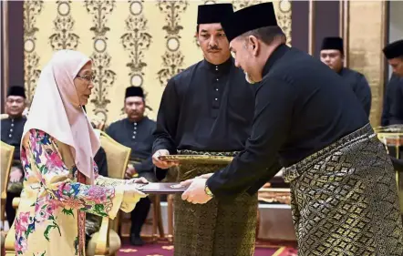  ?? — Bernama ?? Historic moment: The Yang di-Pertuan Agong Sultan Muhammad V presenting the appointmen­t letter to Dr Wan Azizah during the oath of office ceremony at Istana Negara. Wan Azizah is Malaysia’s first woman DPM.