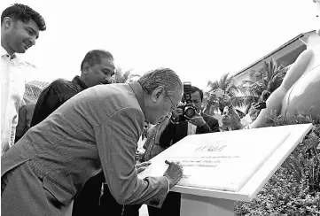  ??  ?? Tun Dr Mahathir signing a plaque to mark the launching of Dash Resort Langkawi yesterday. - Bernama photo