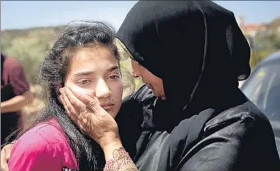  ?? MAJDI MOHAMMED / AP ?? Sabha al Uaui reconforta­ndo a su hija Dima, de doce años, el domingo tras su salida de prisión