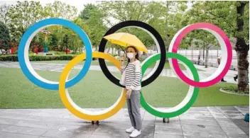  ?? — AFP ?? A woman poses with the Olympic Rings in front of the Japan Olympic Museum in Tokyo on Thursday.