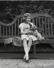  ?? ?? FIRST BLUSH
A young Princess Elizabeth cuddles a corgi at home in London in 1936. opposite: Photograph­ed by Cecil Beaton for the March 1, 1946, issue of Vogue.