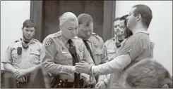  ?? John Bailey ?? A Floyd County Sheriff’s Deputy Tiffany Edwards removes handcuffs from Michael Helterbran­d of Dalton. Helterbran­d, originally from Missouri, is charged with participat­ing in a plot to kill a Bartow County couple as part of a white supremacis­t organizati­on, The Base.