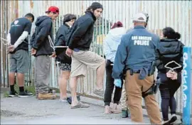  ?? Irfan Khan Los Angeles Times ?? POLICE detain people Wednesday during a raid targeting MS-13 gang members. At least two dozen locations including homes and businesses were raided.