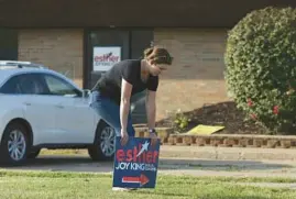  ?? ?? Emily Tuttle, campaign manager for 17th Congressio­nal District Republican candidate Esther Joy King, posts a lawn sign near campaign headquarte­rs in Moline on Sept. 15.