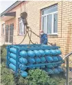  ?? REUTERS ?? Workers unload oxygen balloons, which are used for treating COVID-AND pneumonia patients, outside a local hospital in Dagestan’s Gurbuki village, Russia, in this undated handout picture.
