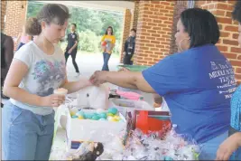  ??  ?? Instructio­nal Assistant Britney McCauley, right, assists 8th grade student Miranda Watson in selecting a prize at the Egg-ceptional Prize Table as part of General Smallwood Middle School’s Walk-A-Thon fundraiser.