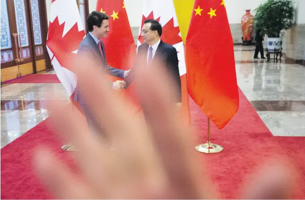  ?? SEAN KILPATRICK / THE CANADIAN PRESS ?? A security guard attempts to block a photograph of Prime Minister Justin Trudeau and Chinese Premier Li Keqiang Monday in Beijing.