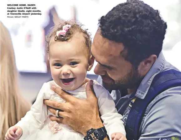  ?? Picture: WESLEY MONTS ?? WELCOME HOME, DADDY: Cowboy Justin O'Neill with daughter Giselle, eight months, at Townsville Airport yesterday.