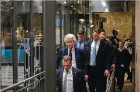  ?? Jasper Juinen / Bloomberg News ?? Geert Wilders, leader of the Dutch Freedom Party, center, enters a parking garage as he leaves the Dutch Parliament following the Dutch elections in The Hague, Netherland­s, on Wednesday.