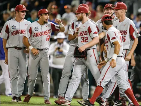  ?? Associated Press ?? To the finals: Arkansas players celebrate around closing pitcher Matt Cronin (32) following an NCAA College World Series game against Florida in Omaha, Neb., Friday. The Razorbacks begin a best-of-3 series with Oregon State for the national championsh­ip tonight.