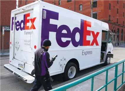  ?? AP FOTO ?? EXPRESS DELIVERY. A FedEx driver returns to his truck in downtown Pittsburgh. FedEx Corp. reported second quarter earnings of $775 million or $2.84 per share, up from $700 million. FedEx chares have increased 30 percent since the beginning of the year.