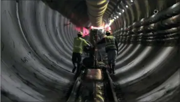  ?? JULIE JACOBSON — ASSOCIATED PRESS ?? In this May 16 photo, tunnel workers push equipment up a rail track to a machine boring a 2.5-mile bypass tunnel for the Delaware Aqueduct in Marlboro, N.Y.
