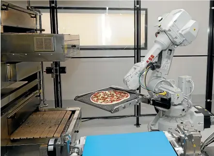  ?? AP ?? A robot places a pizza in an oven at Zume Pizza in Mountain View, California. The Silicon Valley company closed this week, as did three coffee shops in downtown San Francisco that used robots as baristas.