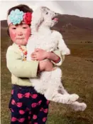  ??  ?? En guise de peluche, cette petite fille a opté pour le plus jeune agneau du troupeau.
