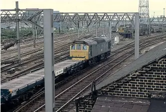  ??  ?? Type 2 No. 25111 hauls a rake of carflat Motorail wagons from an overnight sleeper service through Harlesden, North London, in June 1979. These were a significan­t element of the wagon fleet used on car-carrying services, although being open meant that cars were sometimes susceptibl­e to damage en route.
Martin Addison/Creative Commons (geograph-3711222)